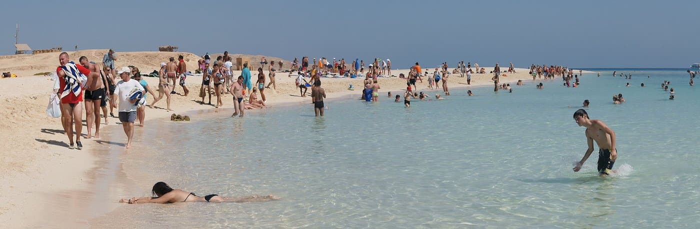 Песчаный пляж острова у Хургады, бирюзовая вода Красного моря и пустынный берег на горизонте