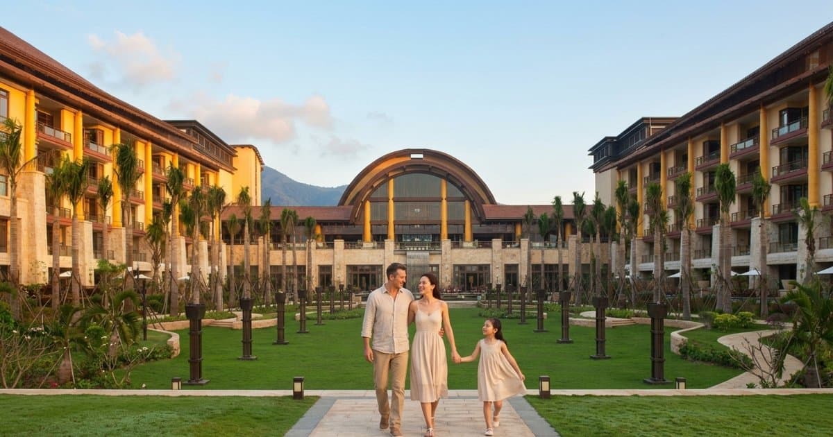 Семья гуляет по саду St. Regis Sanya к главному корпусу